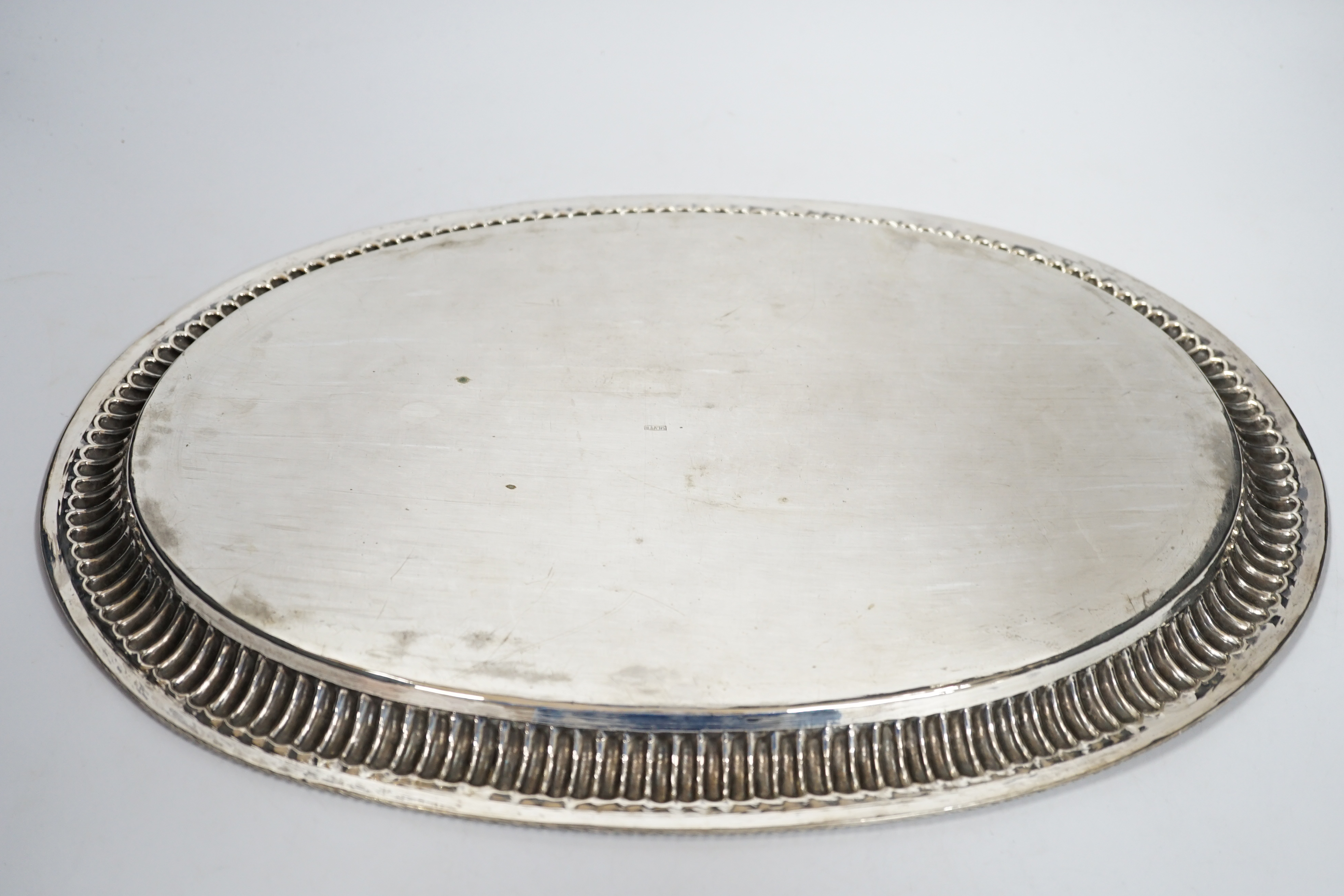 A Far Eastern white metal oval tray, with gadrooned and beaded rim, stamped silver, 45cm